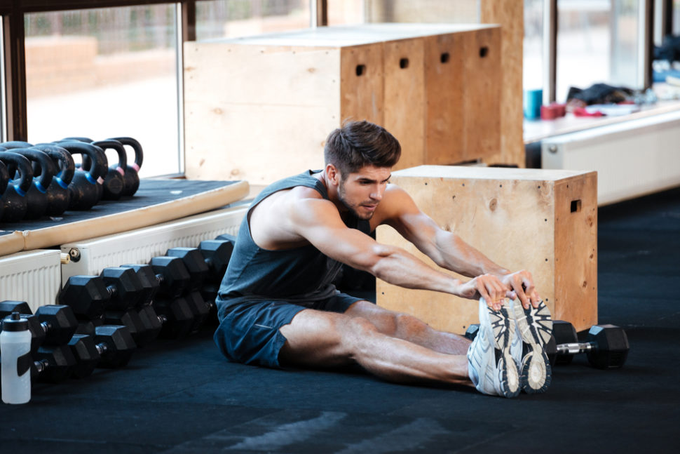 Hoe verminder je spierpijn na het sporten? 1 male athlete stretching before work out 970x647 1
