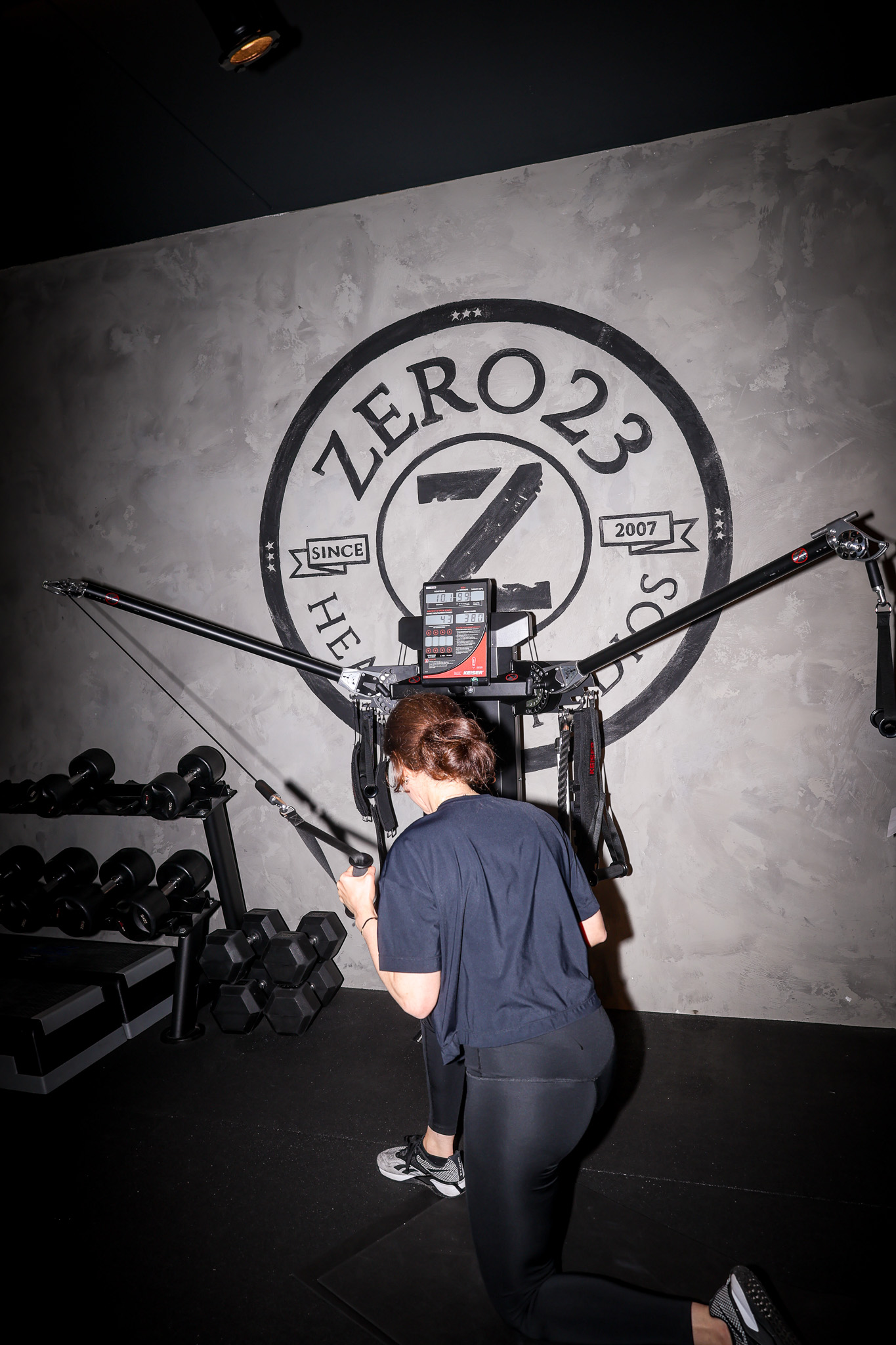 Vrouw tijden een training met een gewichtmachine bij zero23